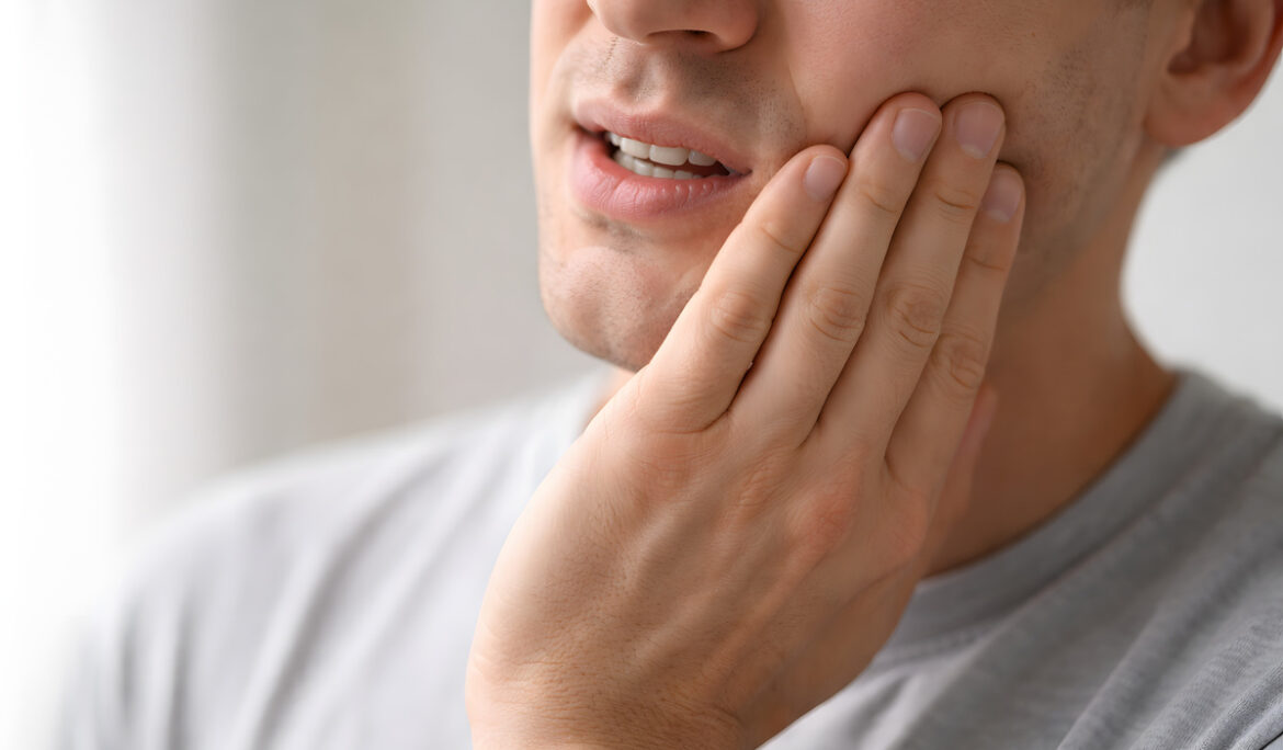 Person Holding Jaw in Pain, Focus on Hand and Lower Face - Dental Pain
