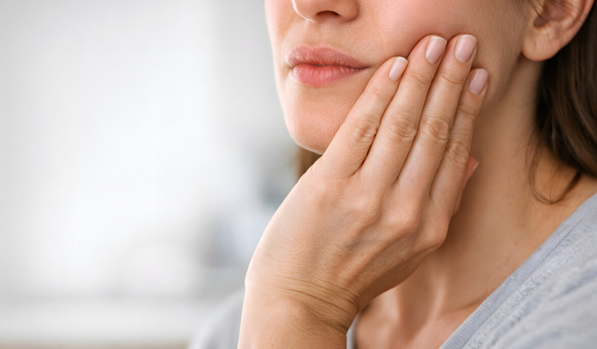 Woman Holding Jaw in Discomfort - Dental Emergency - Tooth Pain