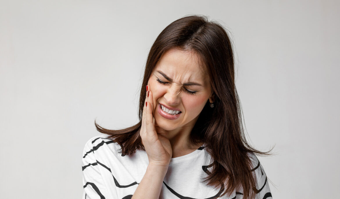 young sad woman suffering from tooth pain
